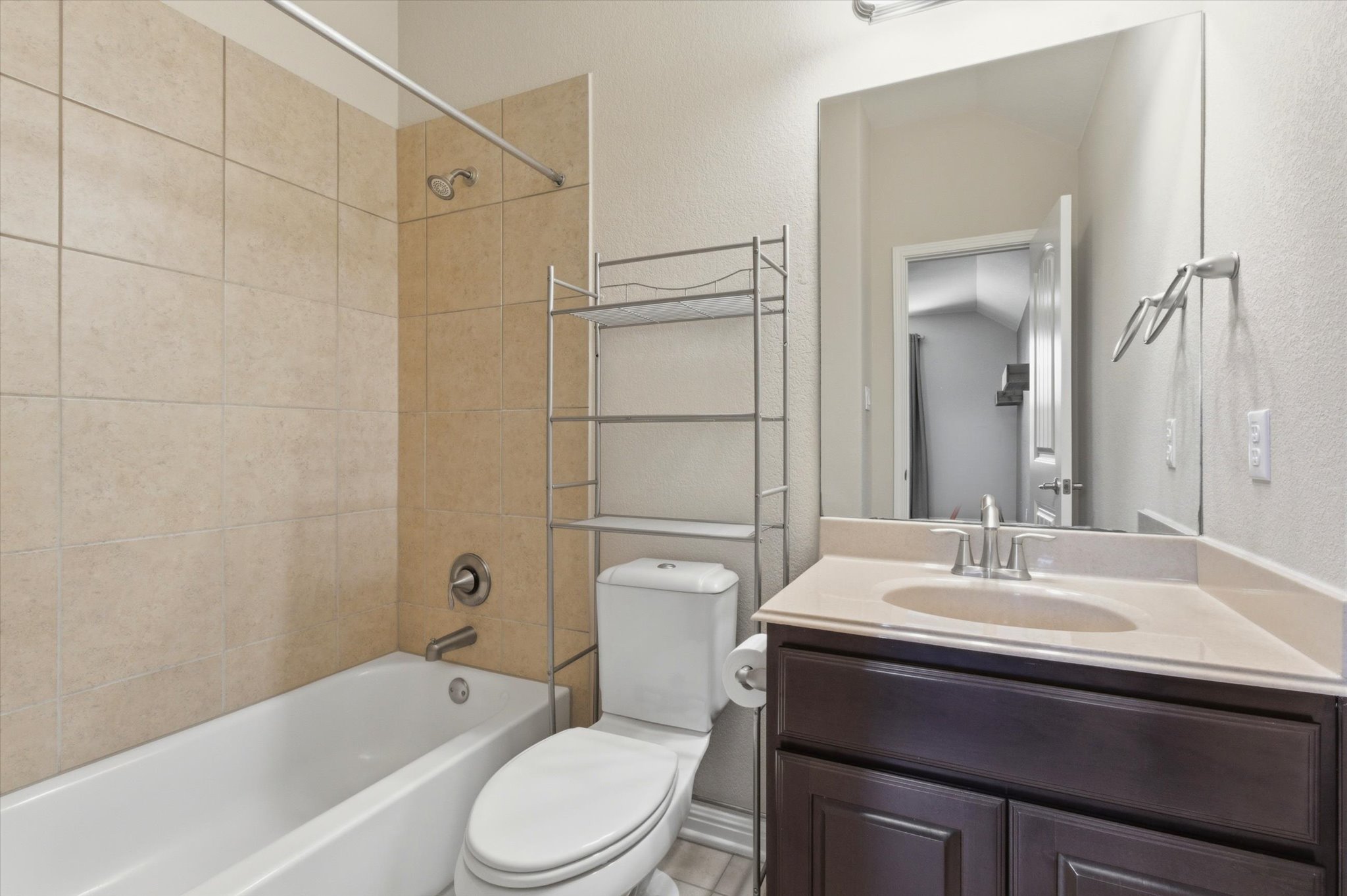 1511 Rimstone Drive Cedar Park, TX 78613 - Photo 27 of 39 A well-appointed bath features a tiled tub and shower combination with a single vanity and mirror.