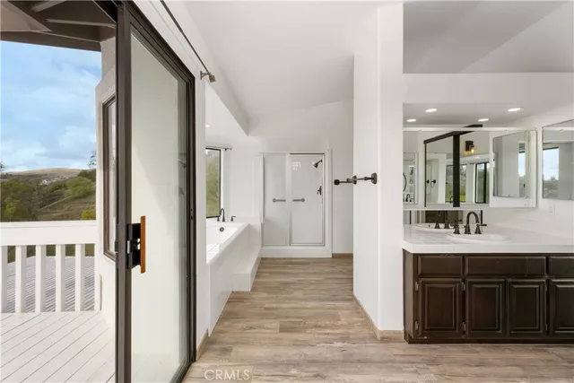 a view of an empty room with a ceiling fan and wooden floor