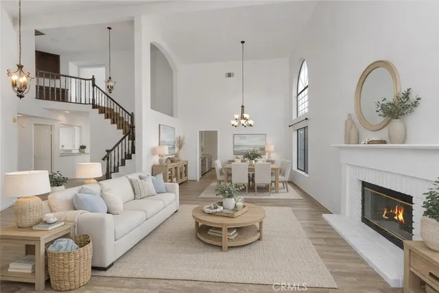 a living room with furniture a fireplace and a chandelier