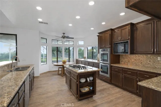 a kitchen with stainless steel appliances granite countertop a sink and a stove