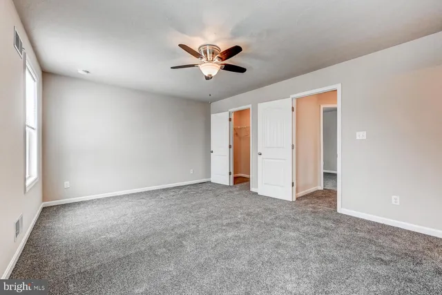 a view of an empty room with a ceiling fan
