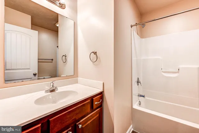 a bathroom with a granite countertop sink a mirror a shower and a bathtub