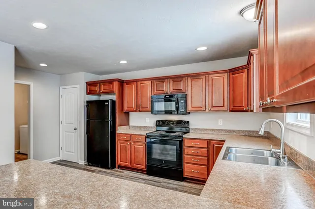 a kitchen with stainless steel appliances granite countertop a refrigerator and a sink