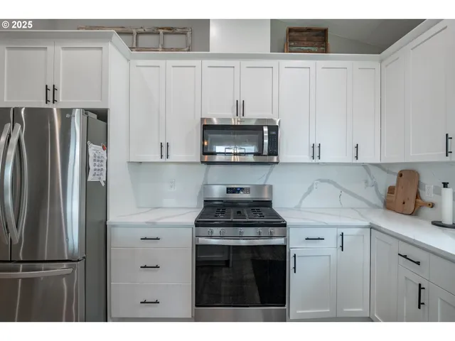 a kitchen with stainless steel appliances granite countertop a stove a refrigerator and a microwave