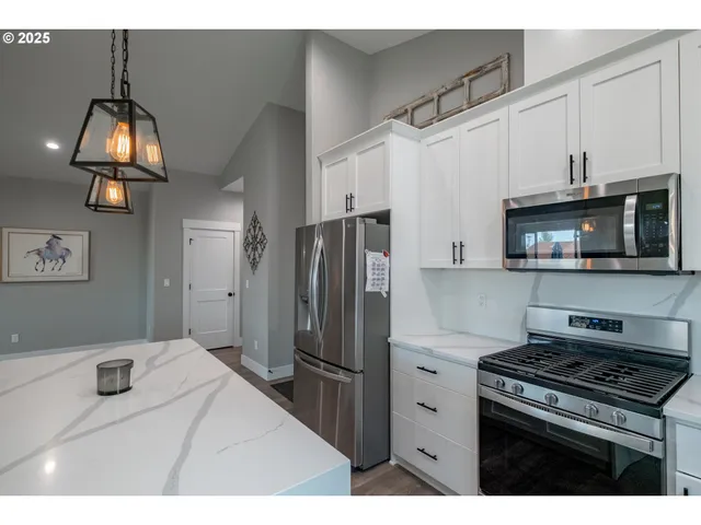a kitchen with a sink a counter top space and living room view