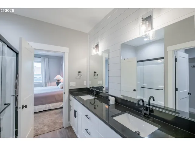 a bathroom with a double vanity sink a mirror and a shower