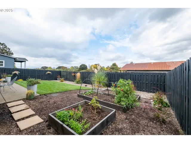 a view of a patio with table and chairs and wooden fence