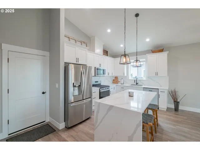 a kitchen with kitchen island a sink stove and refrigerator