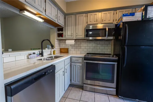 a kitchen with stainless steel appliances a stove a sink and a microwave