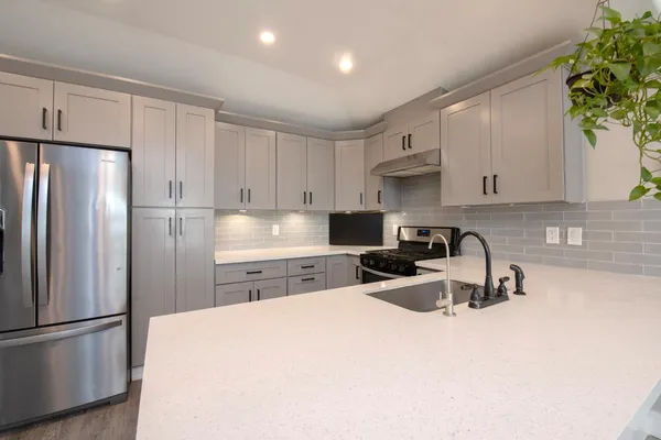 a kitchen with stainless steel appliances a refrigerator sink and cabinets