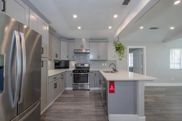 a kitchen that has a sink stainless steel appliances and counter space
