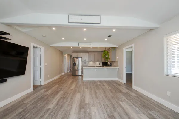a view of a living room a flat screen tv and windows