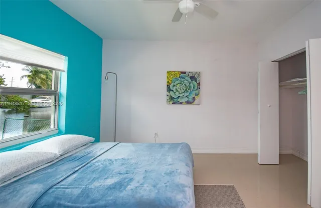 a bedroom with a bed and a large window