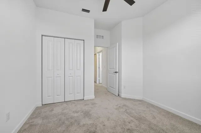 an empty room with closet and windows
