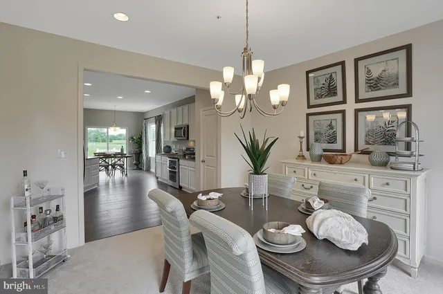 a dining room with furniture a chandelier and wooden floor