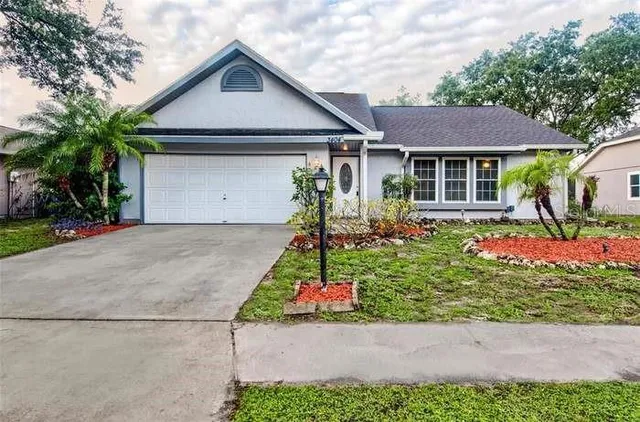 a front view of a house with a yard and potted plants
