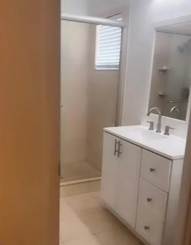 a bathroom with a sink a mirror and shower