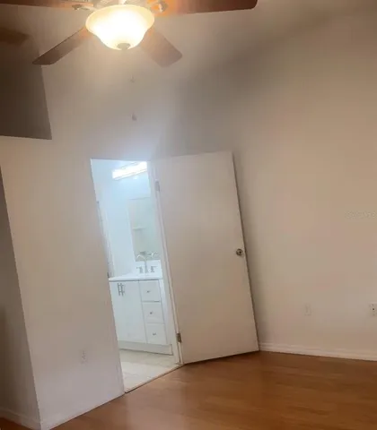 an empty room with wooden floor and mirror