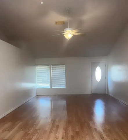 a view of empty room with wooden floor