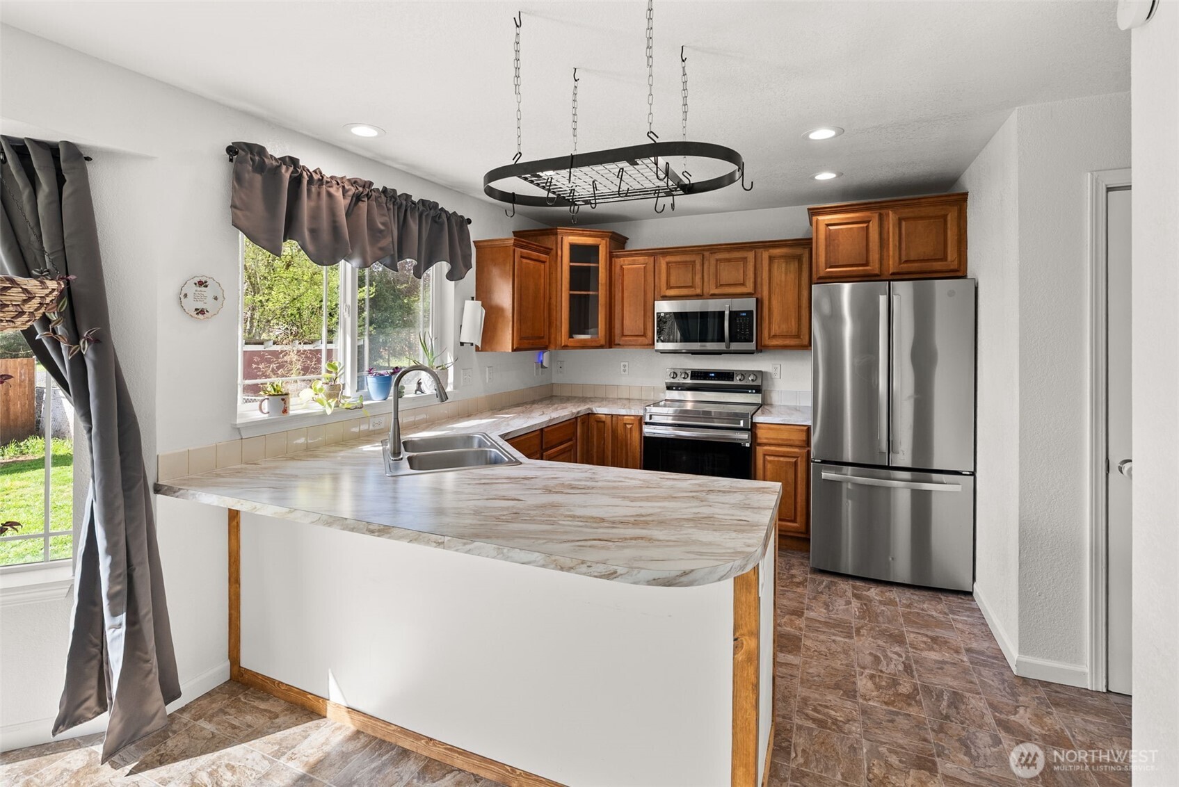 1231 Southwest Elzina Street Chehalis, WA 98532 - Photo 11 of 24 a kitchen with stainless steel appliances granite countertop a refrigerator a stove a sink a microwave oven with a dining table and chairs