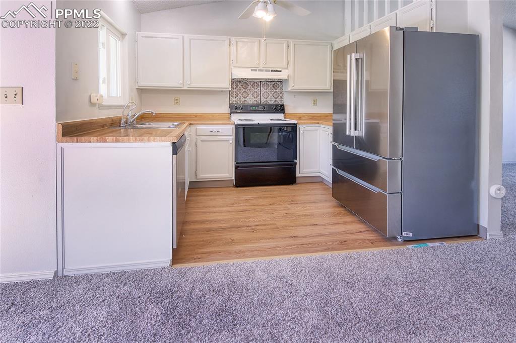 541 Blossom Field Road Fountain, CO 80817 - Photo 5 of 30 a kitchen with a refrigerator sink and cabinets