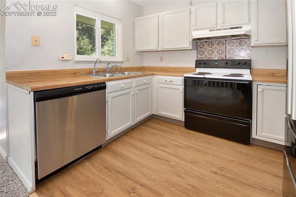541 Blossom Field Road Fountain, CO 80817 - Photo 6 of 30 a kitchen with a sink stove and cabinets