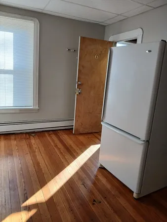 a view of front door with wooden floor and a window