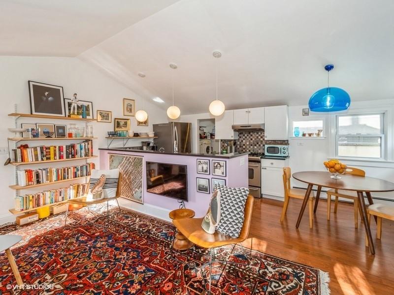 a living room with stainless steel appliances kitchen island granite countertop a rug a stove and a wooden cabinets