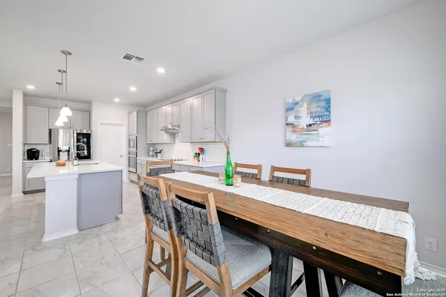 a kitchen with granite countertop a wooden floor and chairs