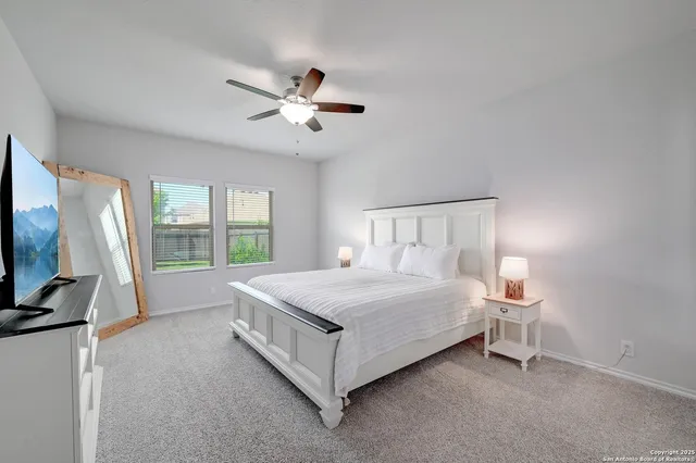 a bedroom with a bed flat screen tv and a large window