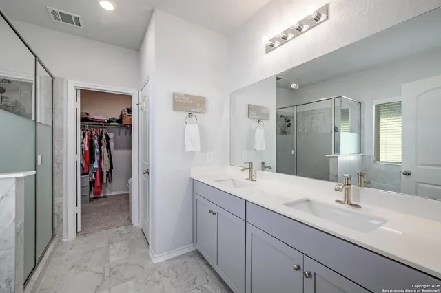 a en suite bathroom with a double vanity sink and a mirror
