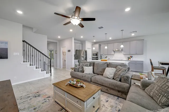 a living room with furniture kitchen view and a chandelier