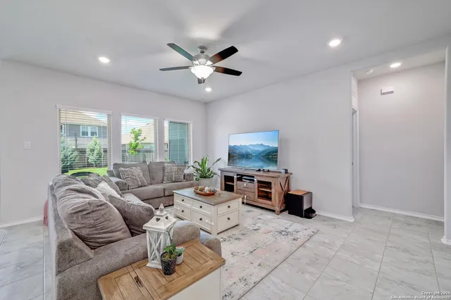 a living room with furniture a window and a flat screen tv