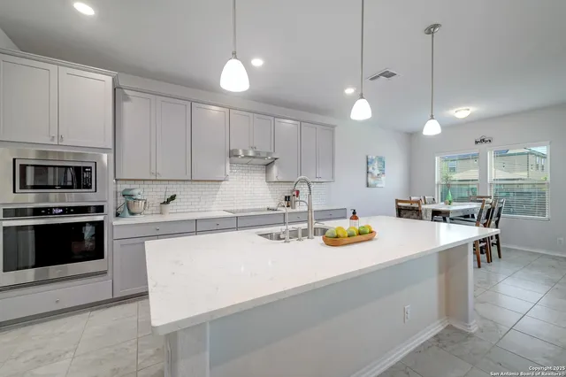 a kitchen with a sink a stove and chairs