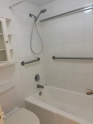 a bathroom with a toilet and a bath tub