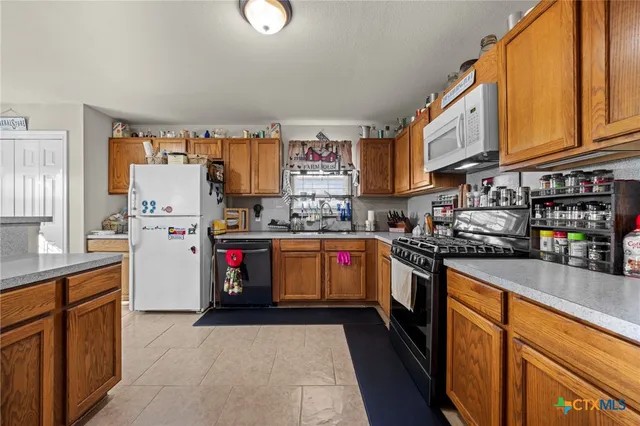 a kitchen with stainless steel appliances granite countertop a refrigerator and a stove top oven