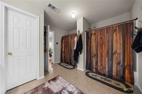a view of a hallway with wooden floor and stairs
