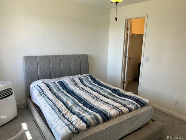 a bedroom with bed and wooden floor