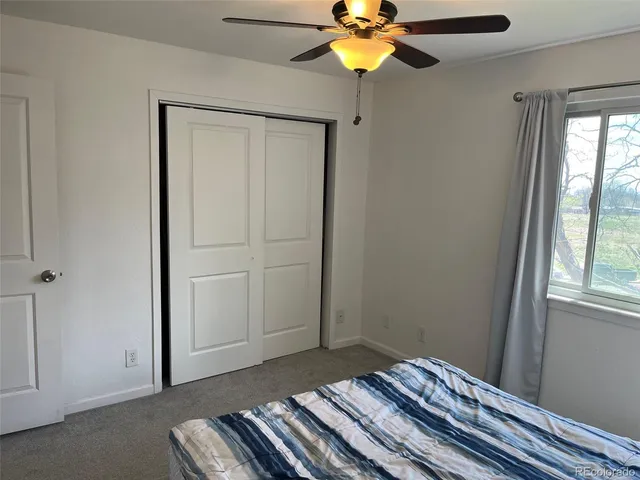 a bedroom with a bed and a chandelier fan