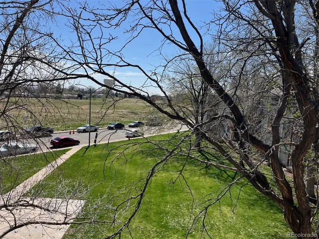 a backyard of a house with table and chairs under an umbrella