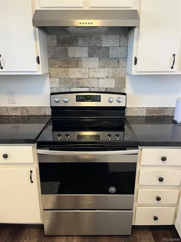 a stove top oven sitting inside of a kitchen
