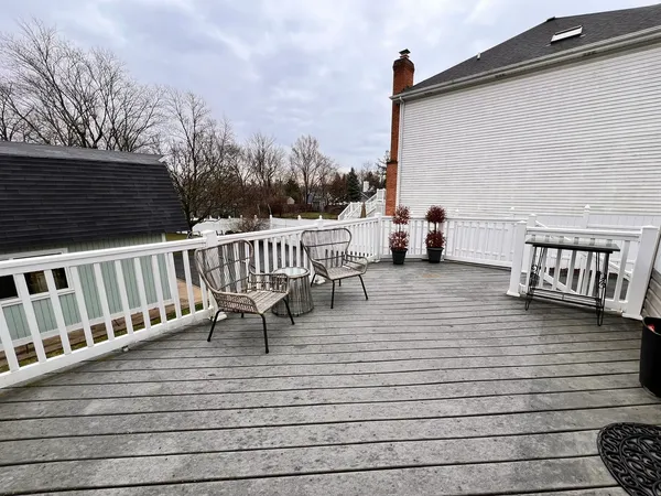 a view of a roof deck with table and chairs and wooden floor