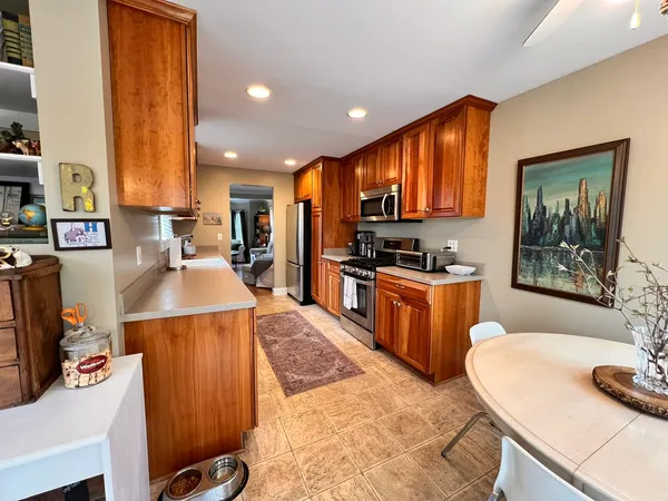 a large kitchen with stainless steel appliances kitchen island granite countertop a sink and cabinets