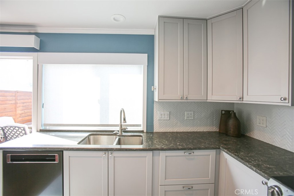 11058 Grant Way Stanton, CA 90680 - Photo 11 of 40 a kitchen with granite countertop a sink and a white cabinets