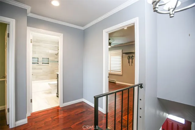 a view of a hallway with wooden floor and staircase