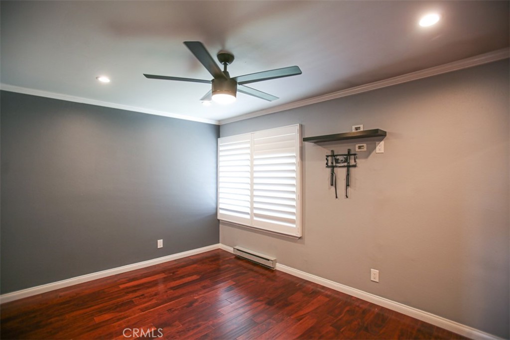 11058 Grant Way Stanton, CA 90680 - Photo 18 of 40 an empty room with wooden floor fan and windows