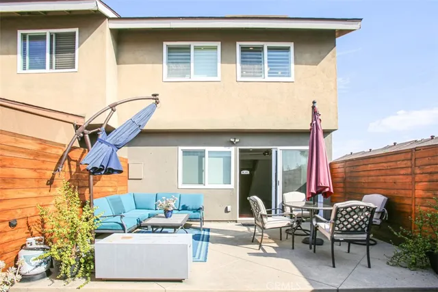 a view of a patio with couches table and chairs and potted plants