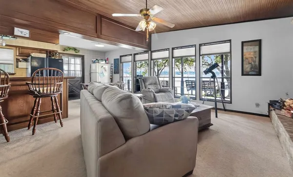 a living room with furniture a chandelier and a large window