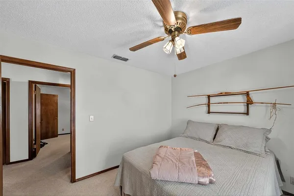 a bedroom with a bed and a ceiling fan