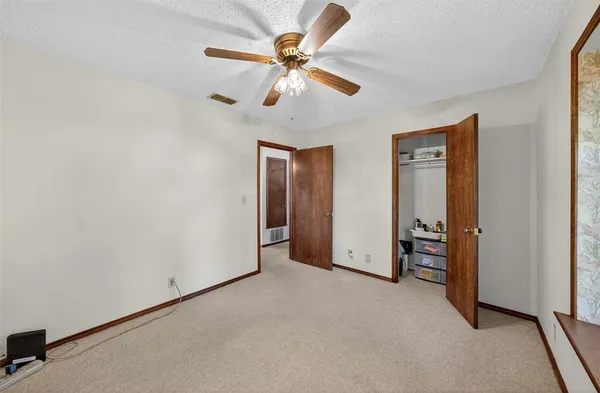 an empty room with closet and fan